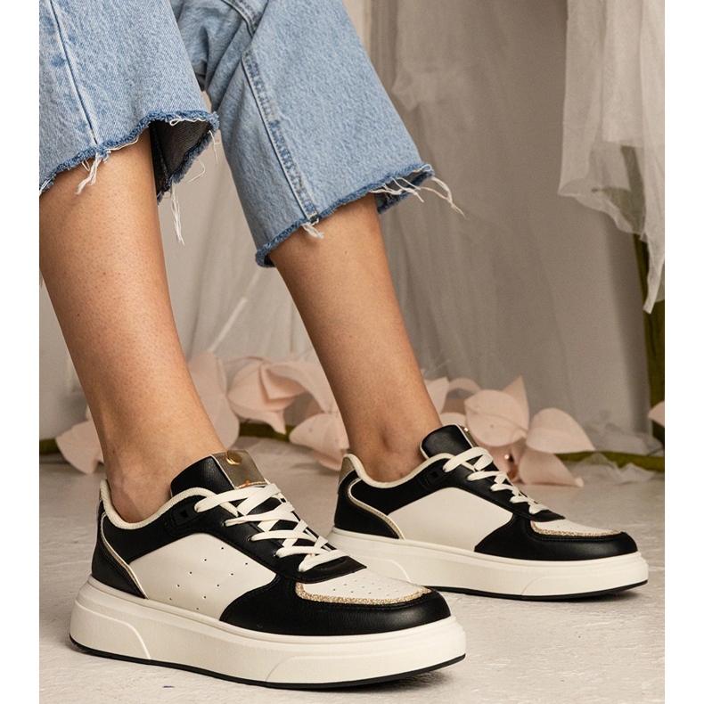 Svarta kvinnors sneakers med ett glittertillbehör 1