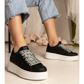 Svarta kvinnors sneakers med massiv snörning = 1