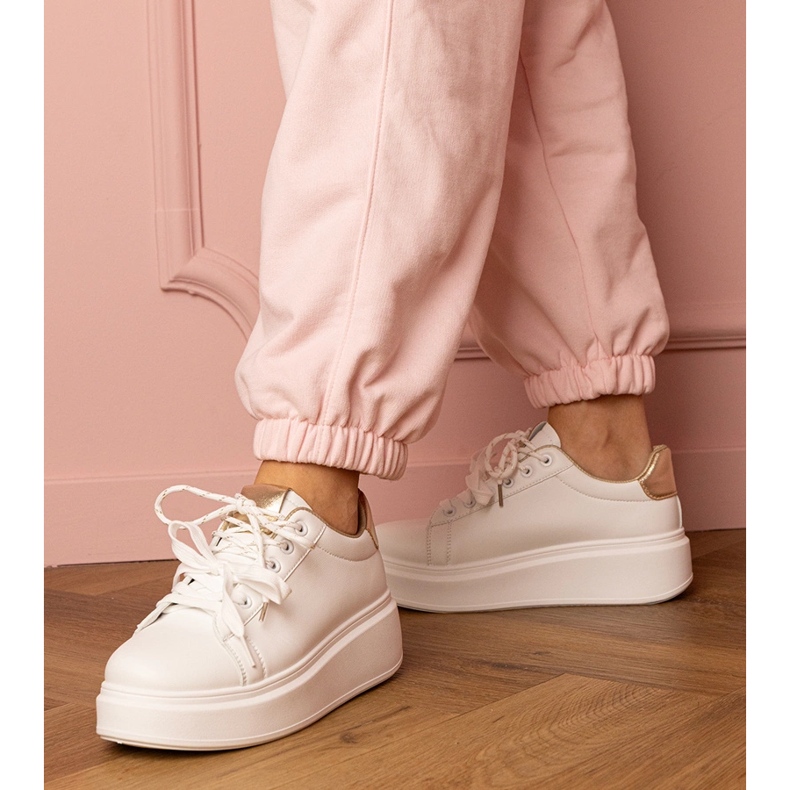 Vita och guldsportsneakers på plattformen 1