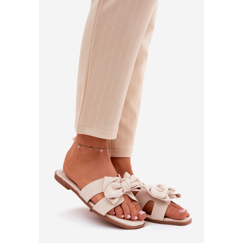 Platta kvinnors flip flops med en båge -beige 1