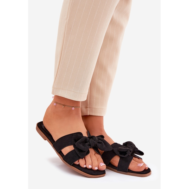 Platta kvinnors flip flops med en svart båge 1