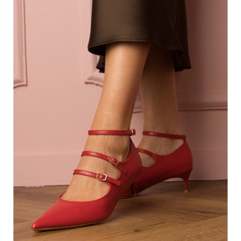 Röda pumpar på en låg hög med spännen 1