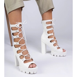 Vita stövlar på en hög pelare med utskärningar 1