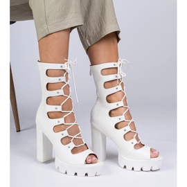 Vita stövlar på en hög pelare med utskärningar 2