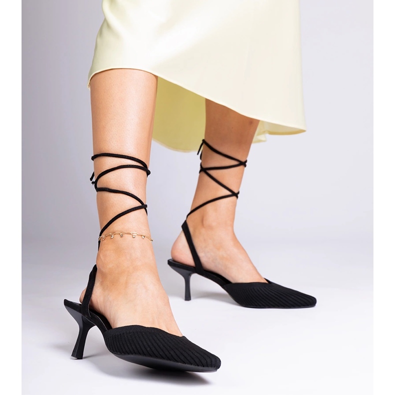 Svarta materialpumpar på en hög häl med öppen 1