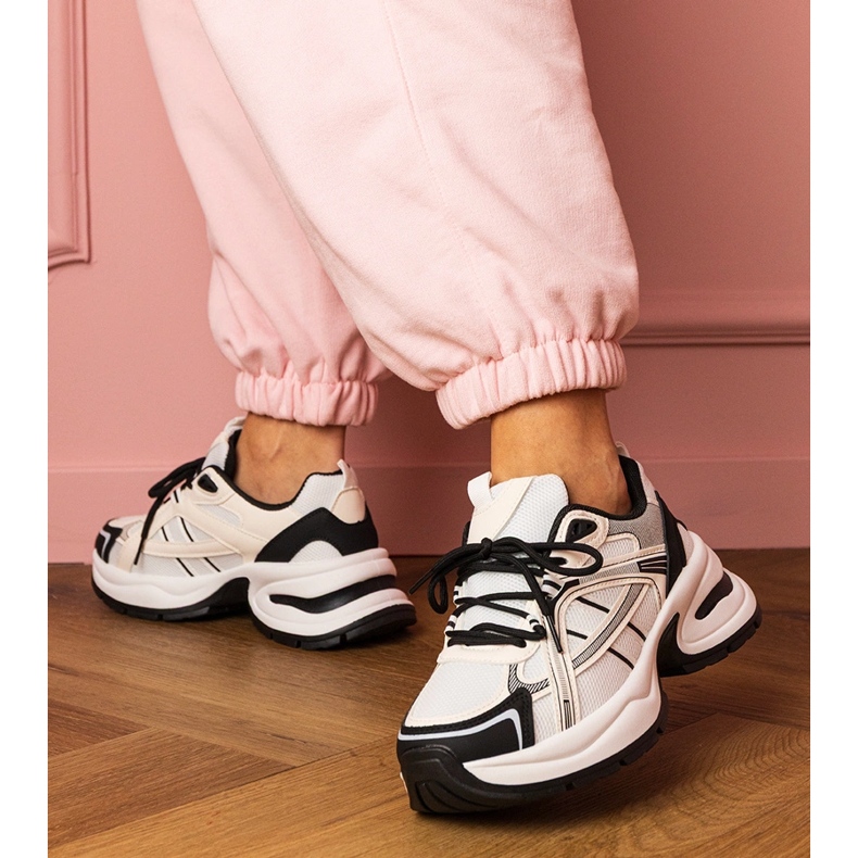 Vita och vita sportsneakers på en massiv sula 1