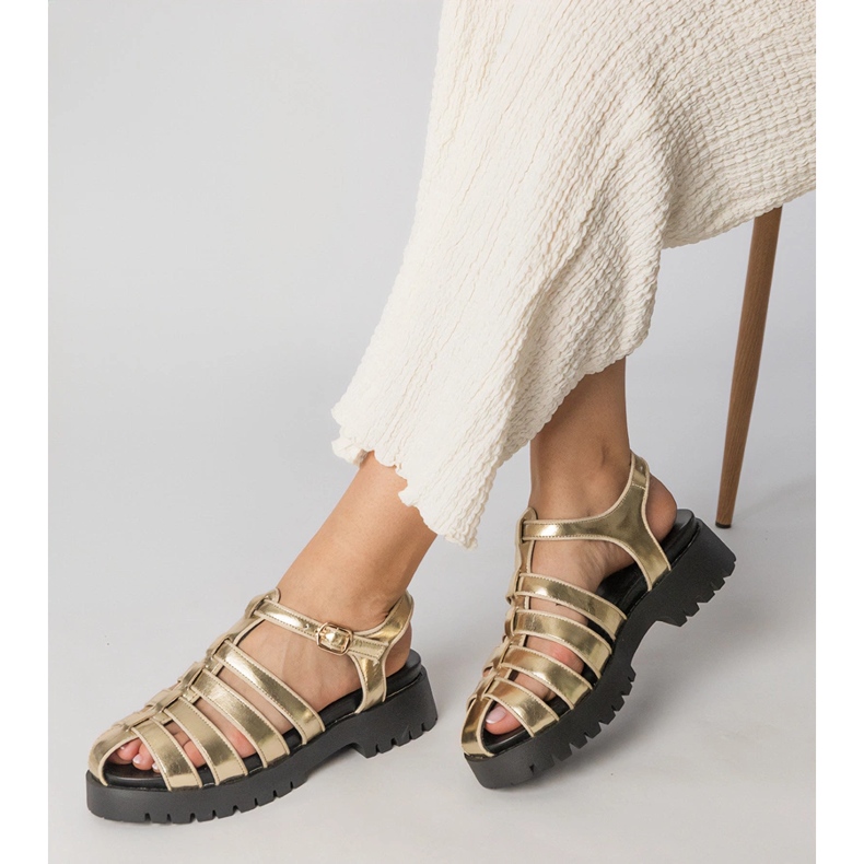 Guldsandaler på plattformen med en fingerlinje byggd gyllene 1