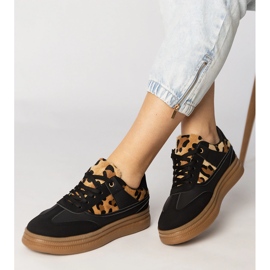 Svarta sneakers med ett leopardtillbehör 2