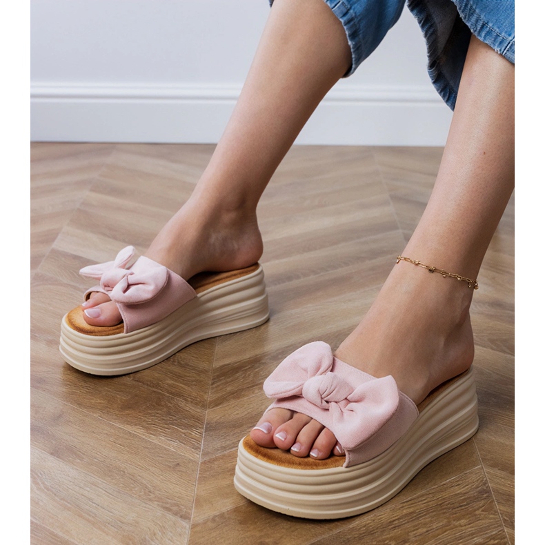 Rosa tofflor på plattformen med en rosett 1