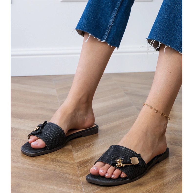 Svarta platt flip flops med en gyllene dekoration 1