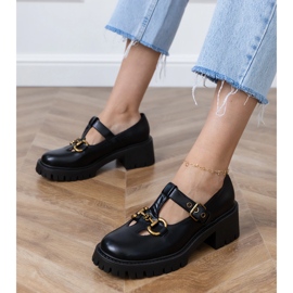 Svarta skor på en tjock sula med en gyllene dekoration 1