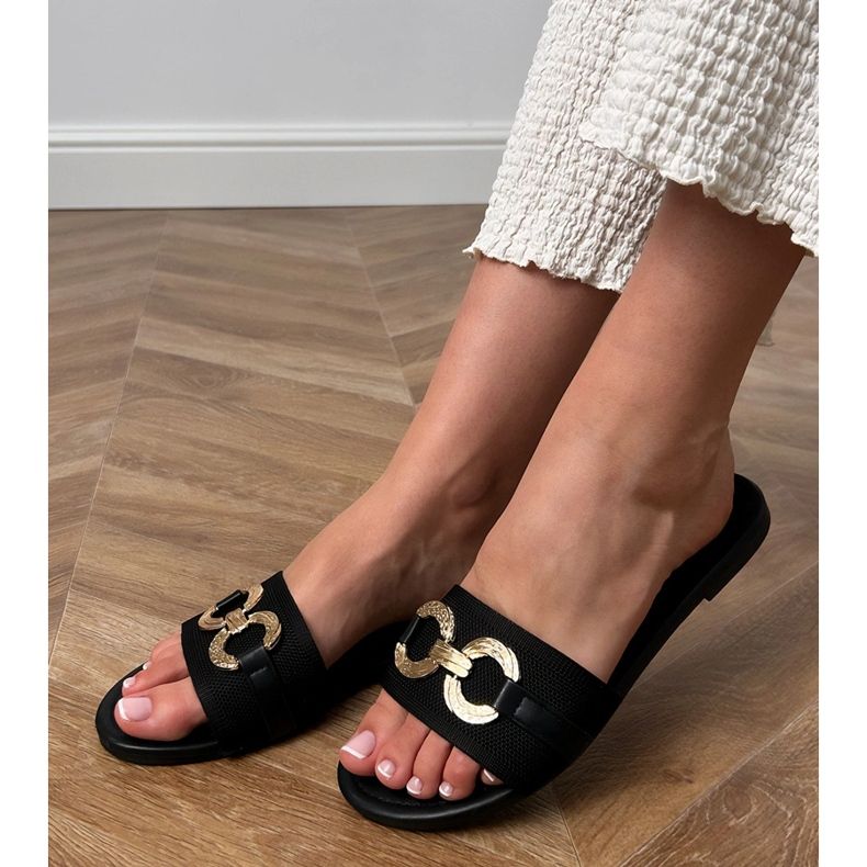 Svarta flip flops med en gyllene dekoration på baren 1