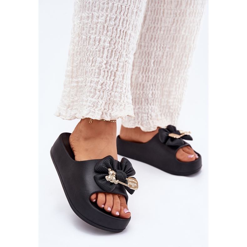 Kvinnors skum tofflor på plattformen med en båge och en svart brosch 2