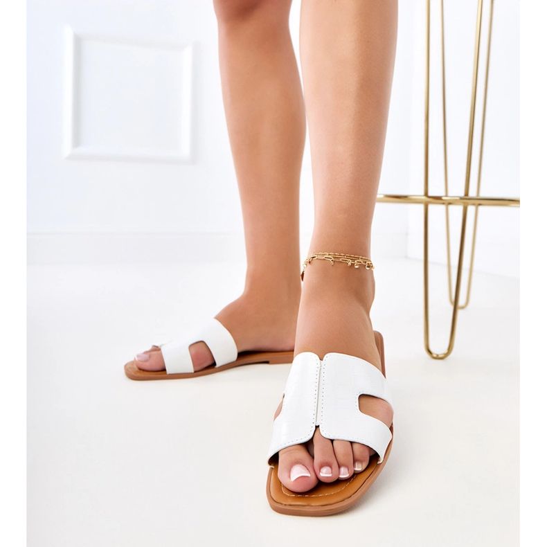 Vita klaffar på en platt sula med pressande 2