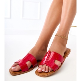 Röda flip -flops på en platt sula med pressande 2