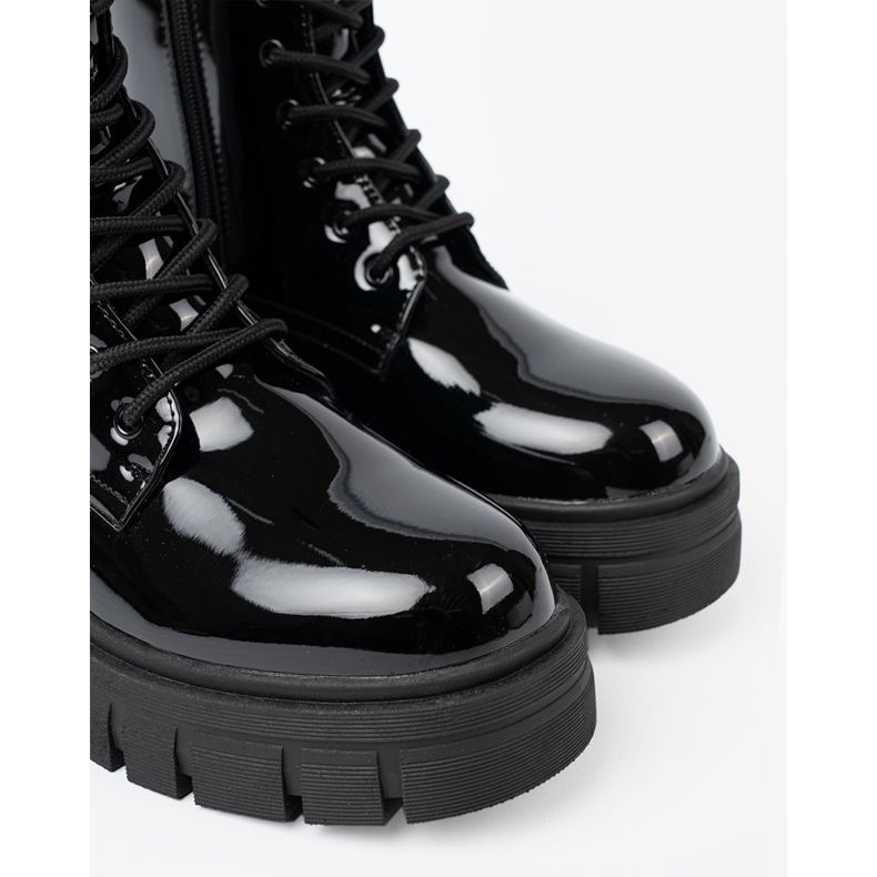 Shelvt Svarta lackerade arbetare på en massiv sula 1