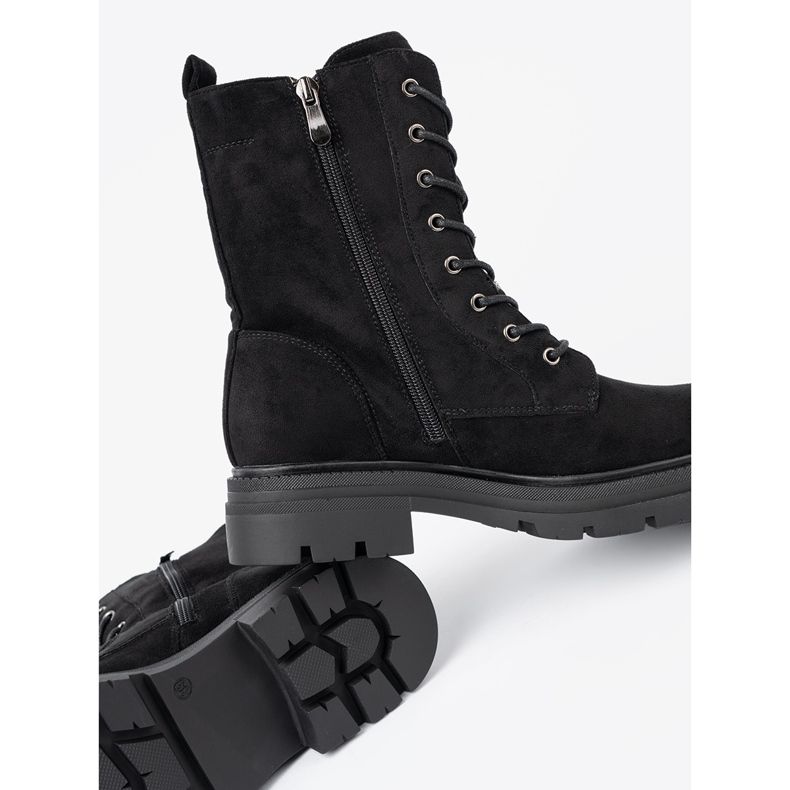 Shelvt Svarta snörda arbetare på en massiv sula 1