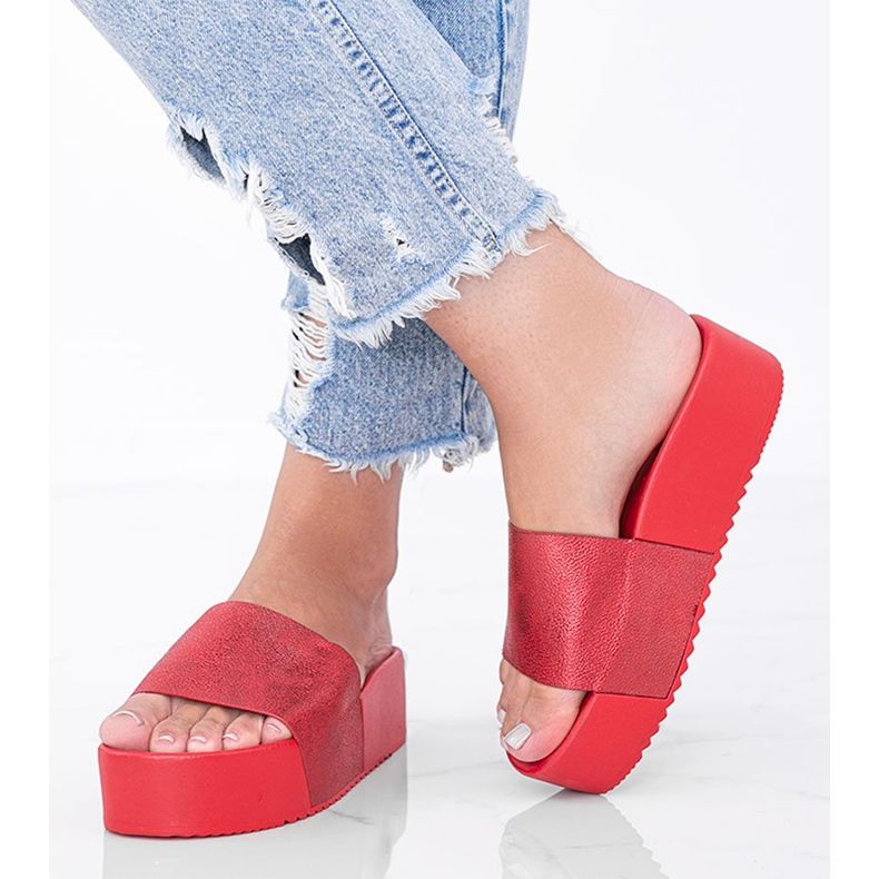 Röda flip-flops på en tjock Crysta-sula 1