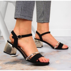 Svarta och guldiga sandaler på stolpen av Sergio Leone gyllene 2