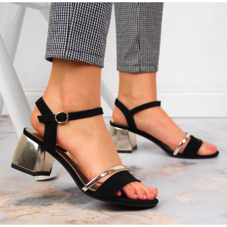 Svarta och guldiga sandaler på stolpen av Sergio Leone gyllene 2