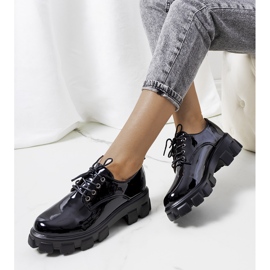 Svartlackade skor på traktorsula Wind 1