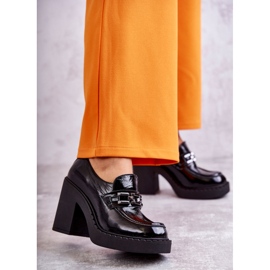 Lackade skor på en massiv svart Jaime-stolpe 1