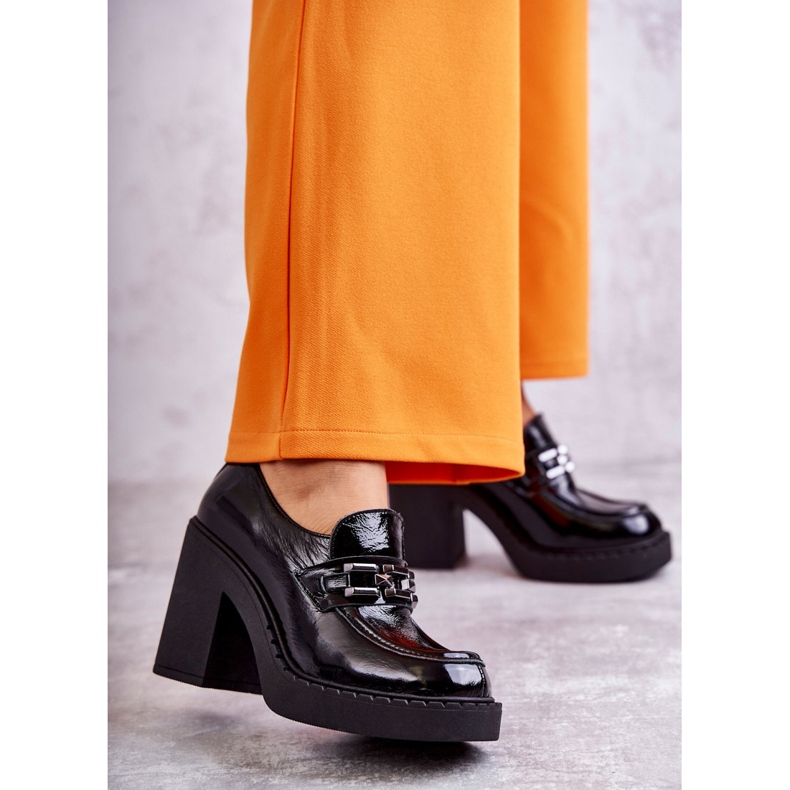 Lackade skor på en massiv svart Jaime-stolpe 1